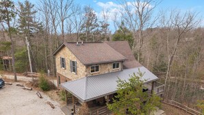 A two-story stone house with a metal roof, surrounded by trees and a gravel driveway. - Your search ends with KSW Cabin. All a group needs, incl. 5 bathrooms. Sleeps 14 (Campton)