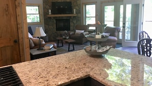 A cozy living room with a stone fireplace, comfortable seating, and a granite countertop. - Your search ends with KSW Cabin. All a group needs, incl. 5 bathrooms. Sleeps 14 (Campton)