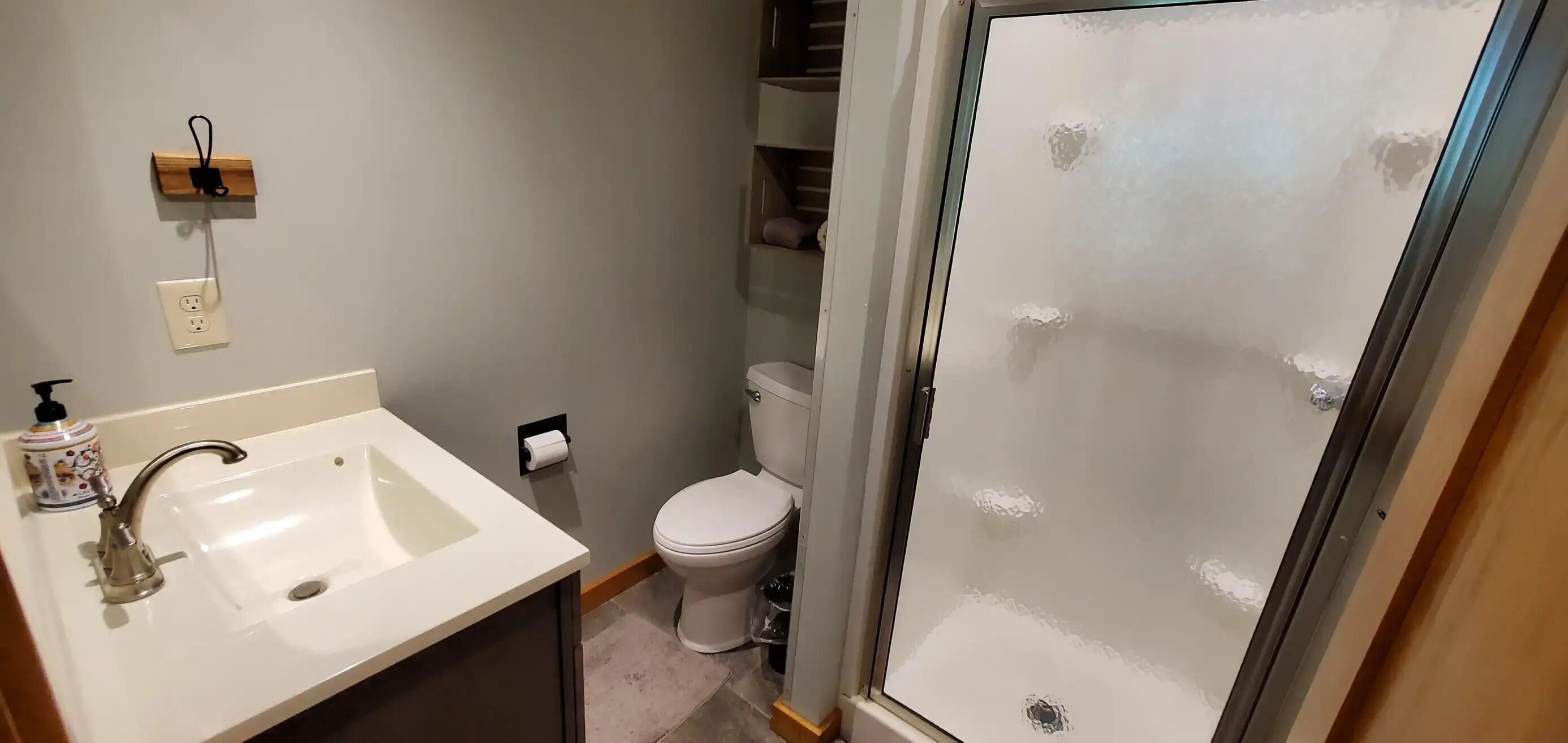 A bathroom with a sink, toilet, and glass shower door.