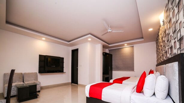 Ein modernes Schlafzimmer mit Bett, Fernseher, Sofa und Deckenventilator.