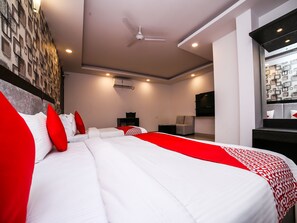 A modern hotel room with a large bed, a ceiling fan, a flat-screen TV, and a wall-mounted air conditioning unit. - OYO 24943 Belmond Palace (New Delhi)
