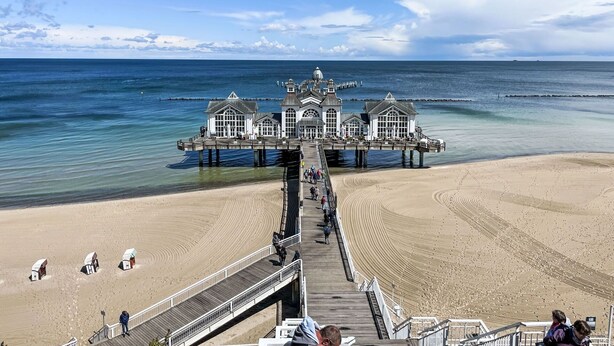 A pier extending into the ocean with a building at the end, a sandy beach, and a clear sky. - Cosy apartment in villa for 4 guests with WIFI, TV, terrace and pets allowed (Sassnitz)