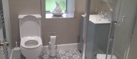 A bathroom with a toilet, bidet, and shower stall.
