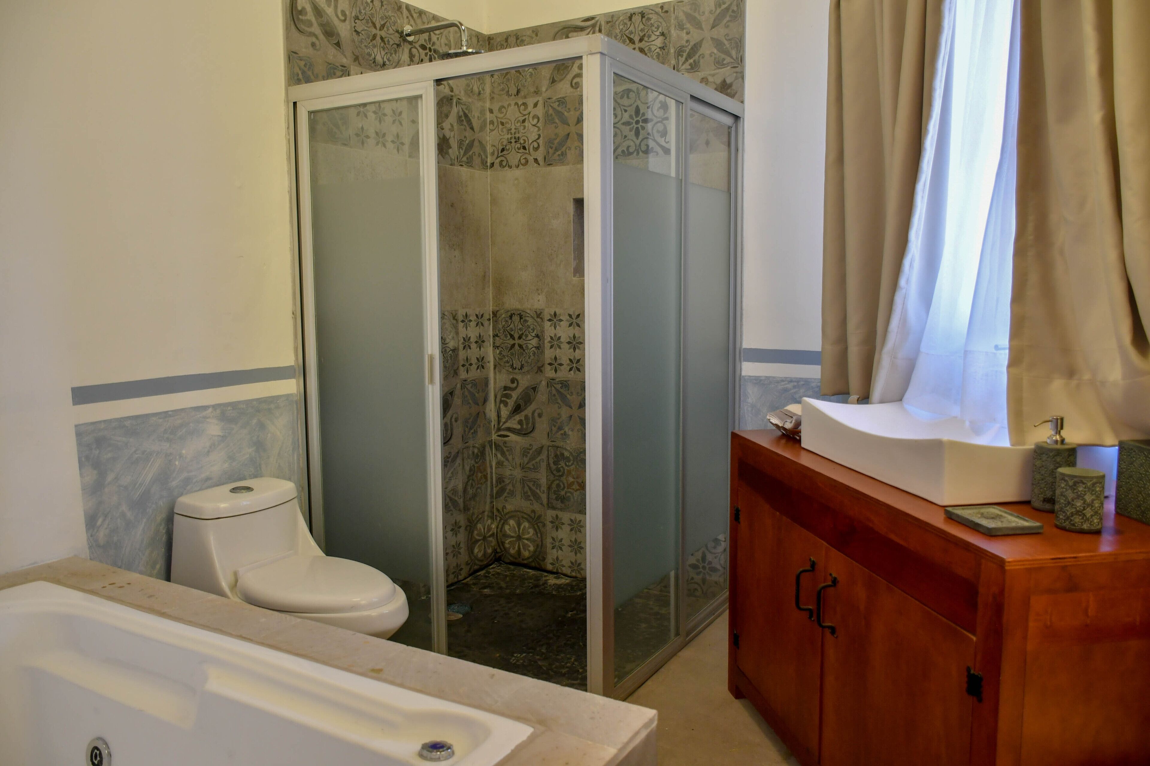 Une salle de bain avec une douche, des toilettes et un meuble-lavabo.