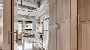 Eine moderne Küche mit Holzausstattung, Edelstahlgeräten und einem großen Fenster für natürliches Licht.