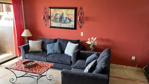 A living room with a sofa, armchairs, a patterned coffee table, and a painting on the wall. - Marina Pinacate 306 Sandy Cove Refuge Wonderful Ocean View Condo (Puerto Peñasco)