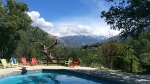 Une piscine avec vue sur les montagnes et les arbres.