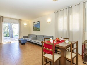 Un comedor con mesa, sillas y sofá.