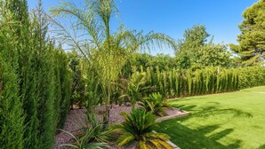 Un jardín bien cuidado con diversas plantas y un césped impecable.