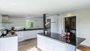 Una cocina moderna con armarios blancos, una encimera negra y una isla grande.