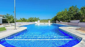 A rectangular swimming pool with a tiled edge, surrounded by a low wall and a fence. - Villa Lourdes Alhaurín de la Torre by Ruralidays (Málaga)