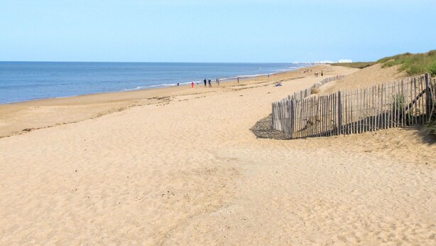 A sandy beach with a wooden fence and a few people in the distance. - Lovely apartment in villa for 4 guests with WIFI, pool, TV, terrace and pets allowed (Saint-hilaire-de-riez)