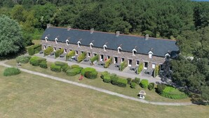 A long, low-roofed building with multiple windows and a paved driveway. - Lovely apartment in villa for 6 guests with WIFI, TV, terrace and pets allowed (Le Carquois)
