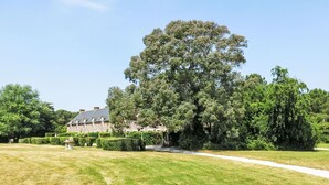 A large tree in front of a stone building with a pathway leading to it. - Lovely apartment in villa for 6 guests with WIFI, TV, terrace and pets allowed (Le Carquois)