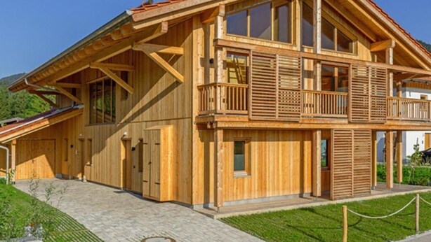 Un grand bâtiment en bois doté d’un balcon et d’une entrée couverte.