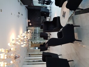 Relax in a stylish seating area with a unique chandelier and glass partition.