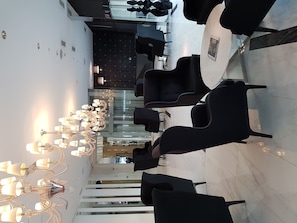 Relax in a stylish seating area with a unique chandelier and glass partition.