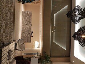 Experience the sleek, modern design of this stylish space, featuring a geometric patterned wall, sleek bench, and minimalist decor.