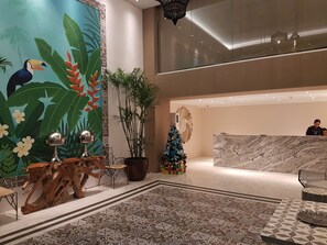 Experience the vibrant atmosphere of our lobby, featuring a stunning mural, comfortable seating area, and warm reception desk.