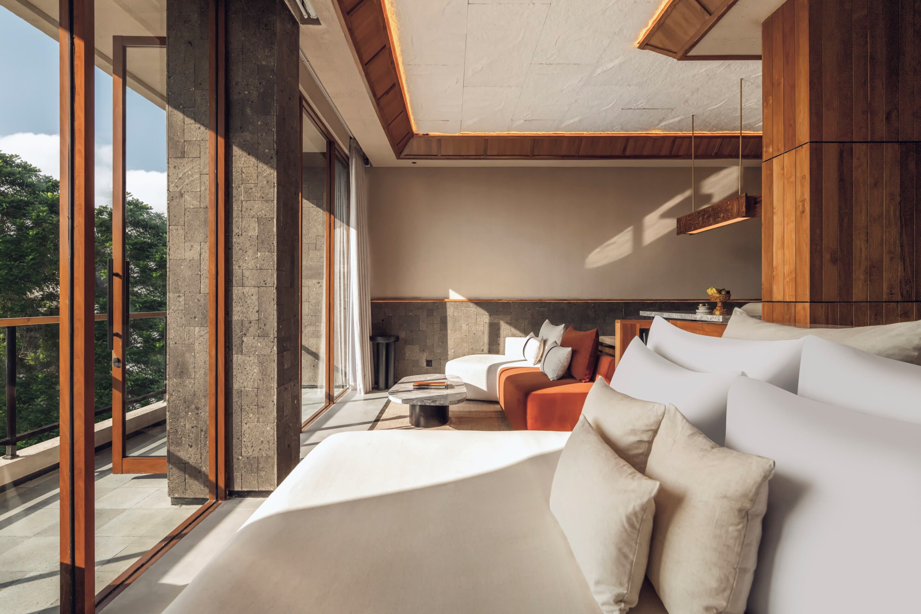 A modern bedroom with a large bed, a sofa, and a dining area.