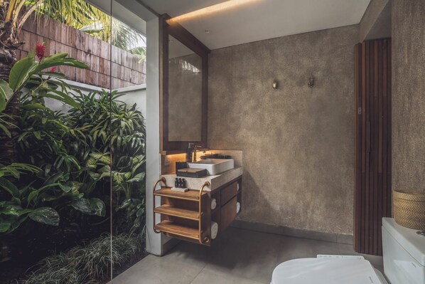 A modern bathroom with a wooden vanity, a large mirror, and a built-in sink. - Kaamala Resort & Spa Ubud by Ini Vie Hospitality (Ubud)