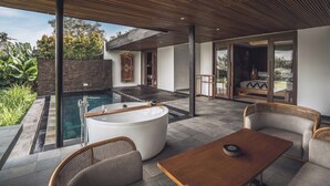 Un área de piscina exterior moderna con un jacuzzi, asientos y vistas del paisaje circundante.