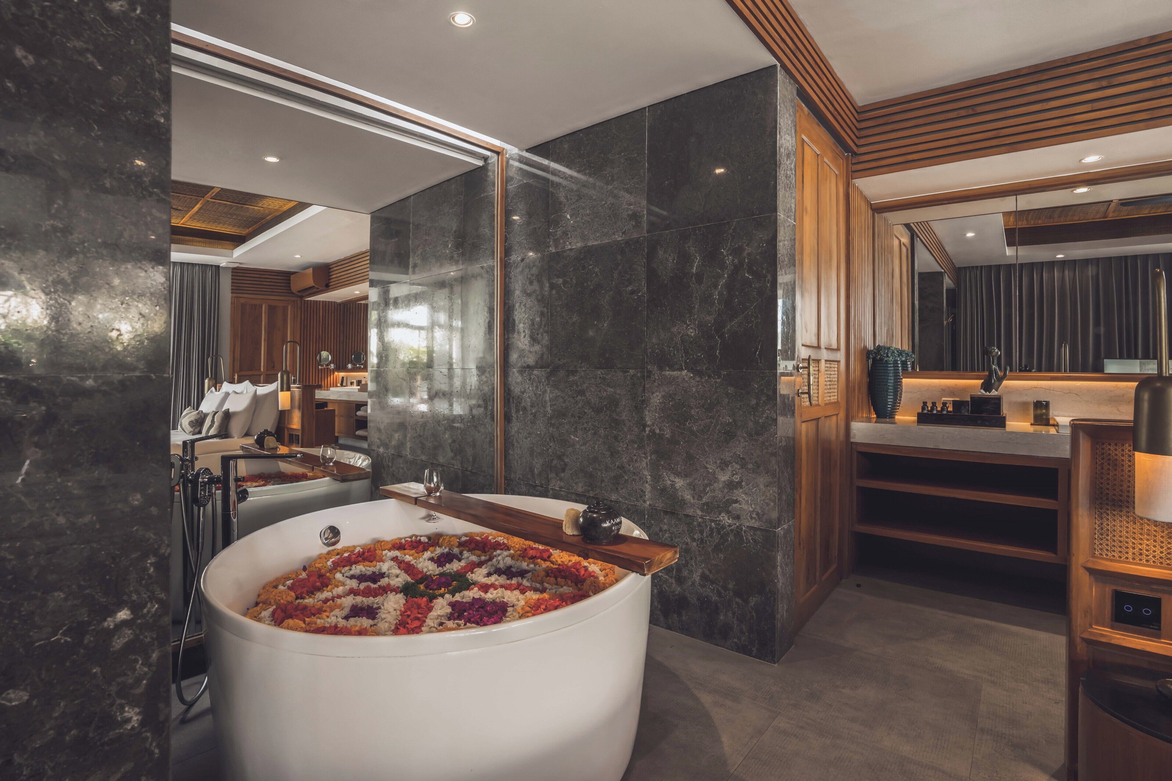 Un baño moderno con una bañera grande, paneles de madera y una pared de mármol.