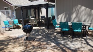 An outdoor patio area with a barbecue grill, multiple chairs, and a table. - Updated Cottage on 6+ wooded acres, Horse setup, RV Hookups, Secluded not remote (Valley Springs)