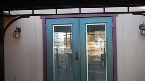 A double door with a purple frame and a window with blinds, set against a white wall. - Updated Cottage on 6+ wooded acres, Horse setup, RV Hookups, Secluded not remote (Valley Springs)