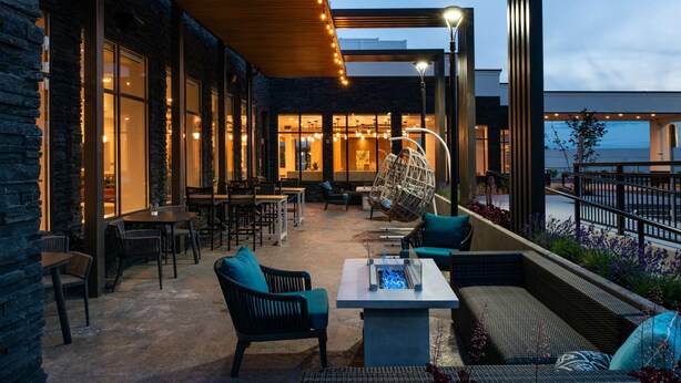 Un espace extérieur aménagé avec des tables, des chaises et un foyer.