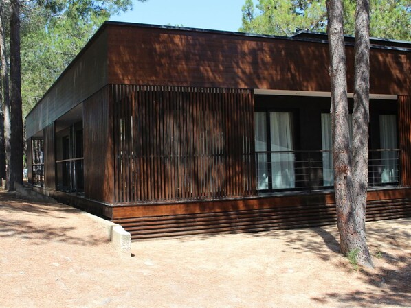 A modern building with a wooden exterior, large windows, and a sloped roof.