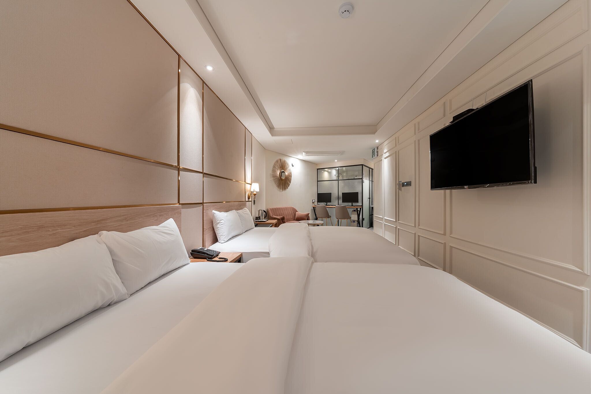 A hotel room with two beds, a TV, a desk, and a chair.