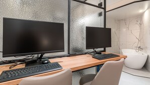 A modern office space with two monitors, a keyboard, and a wooden desk. - Songpa Boutique Hotel XYM (Seoul)