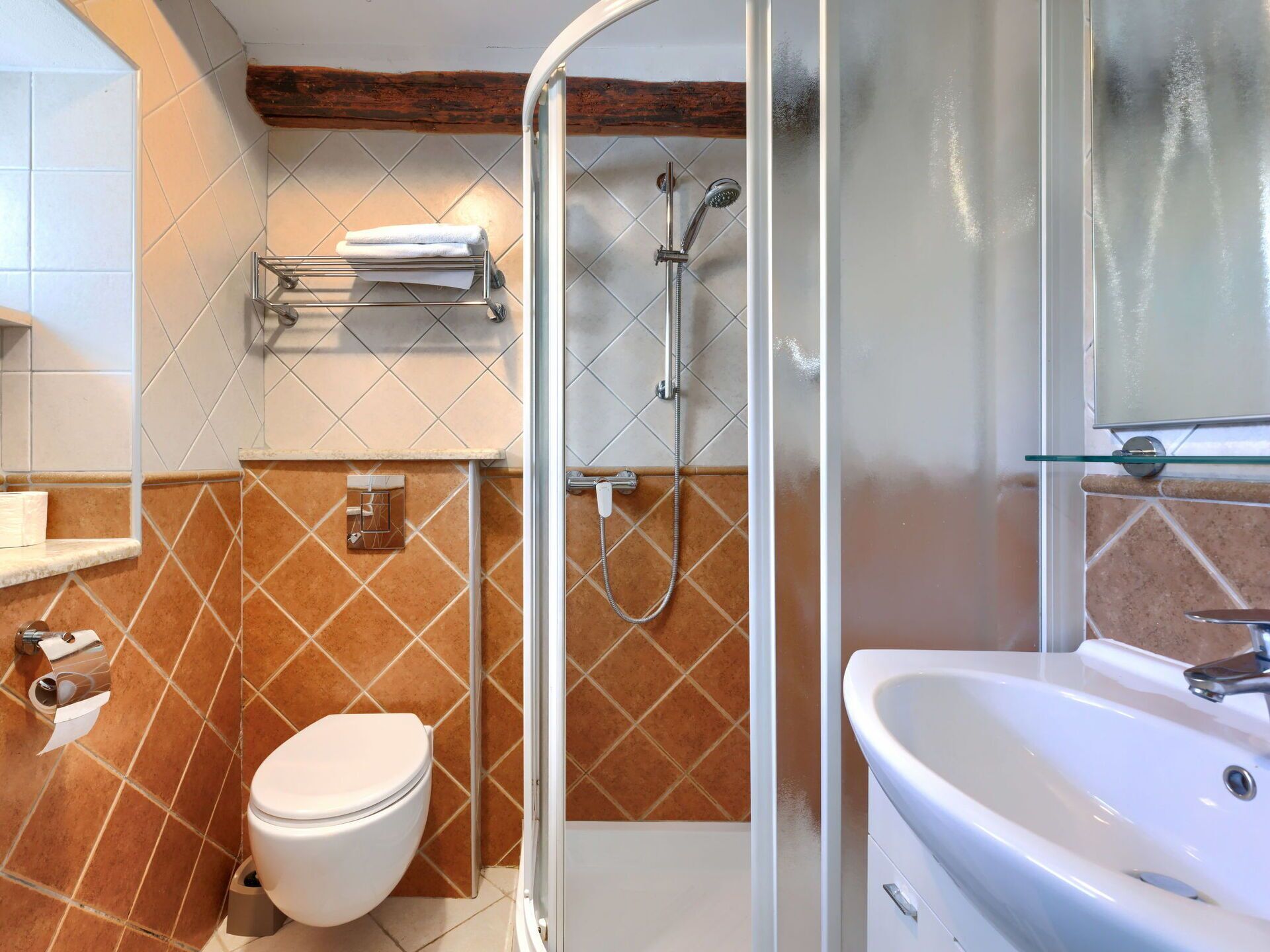 A bathroom with a shower, toilet, and sink.