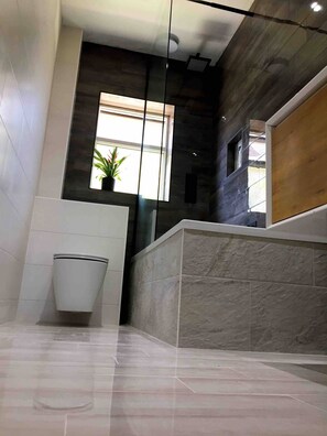 Een bad/douchecombinatie, handdoeken