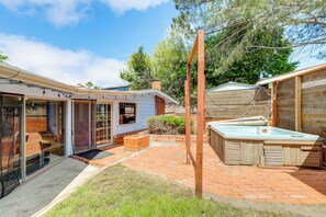 A backyard with a hot tub, a brick patio, and a wooden deck. - Walk to the Beach! Spacious 6BR La Jolla Home (La Jolla)