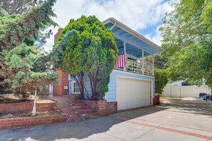 Een woonhuis met garage, een boom ervoor en een Amerikaanse vlag op het dak.