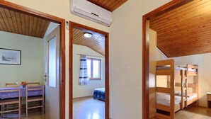 A room with a wooden ceiling, a bunk bed, a desk with a chair, and a window with curtains. - Cosy apartment for 4 guests with WIFI, A/C, TV and terrace (Valdebek)