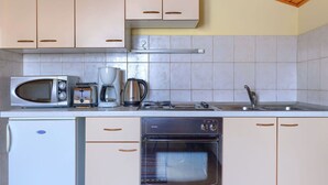 A compact kitchen with a microwave, coffee maker, kettle, and oven. - Cosy apartment for 4 guests with WIFI, A/C, TV and terrace (Valdebek)