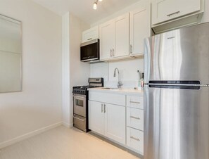 Enjoy cooking in this well-equipped kitchen with a microwave, sink, and refrigerator.