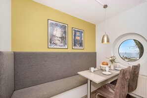 Ein Essbereich mit einer Bank, einem Tisch und zwei gerahmten Bildern an der Wand.