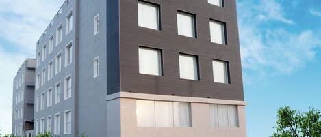A modern hotel building with a flat roof, multiple windows, and a sign reading "Tulip Inn Hotel".