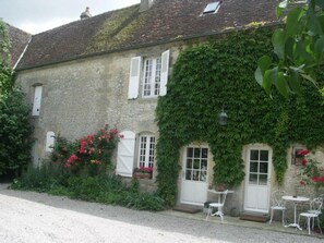 A stone building with white shutters, ivy-covered walls, and a gravel driveway. - Cozy house near Argentan - 9 guests (Sarceaux)