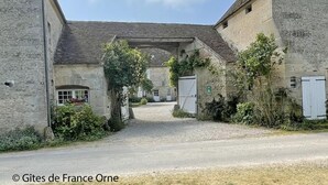 A stone building with a gravel driveway and a covered passageway. - Cozy house near Argentan - 9 guests (Sarceaux)