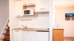 A compact kitchen with a microwave, dishwasher, and sink. - Duplex 2 Rooms for 4 People with Balcony in Vignec (Vignec)