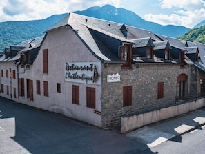 Um edifício com uma fachada que exibe a placa 'Restaurant L'Authentique' e 'VIGNEC'.