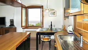 A compact kitchen with a dining area, a window with a view, and a built-in oven. - Beautiful apartment for 4 guests with A/C, WIFI, TV and balcony (Labin)