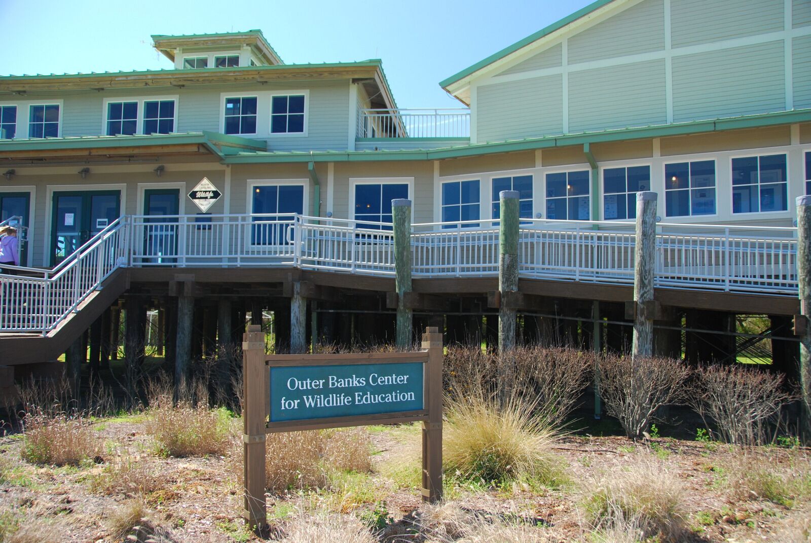 Un bâtiment sur lequel est apposée une enseigne indiquant : « Centre d’éducation à la faune sauvage d’Outer Banks ».