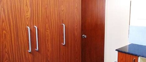 A wooden wardrobe with two handles and a door.