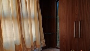 A wooden wardrobe with a mirror and a shelf. - Studio Apartment Suite with kitchenette (THIRUVANANTHAPURAM)
